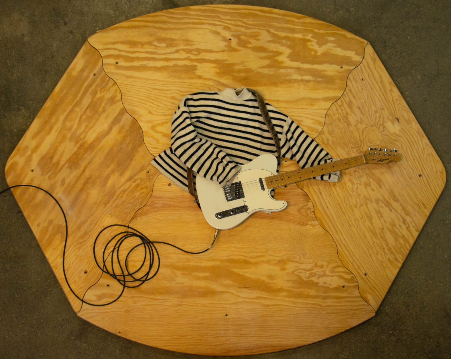 Une graine de parquet miel avec un pull et une guitare électrique